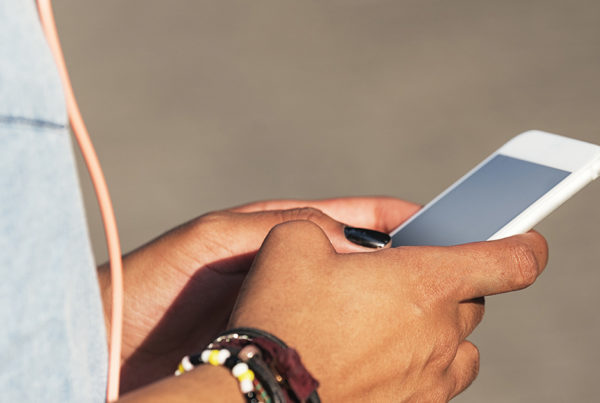 Close up of a teenagers hands holding a smartphone.