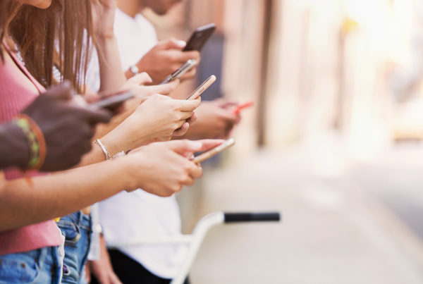 Group of young friends using smart phone in an urban area.