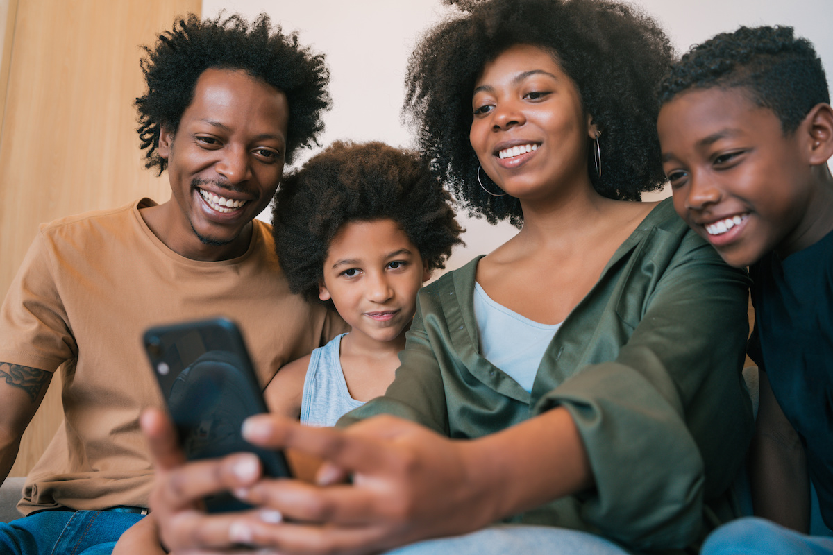 Portrait of family taking a selfie together with mobile phone at home. Family and lifestyle concept.