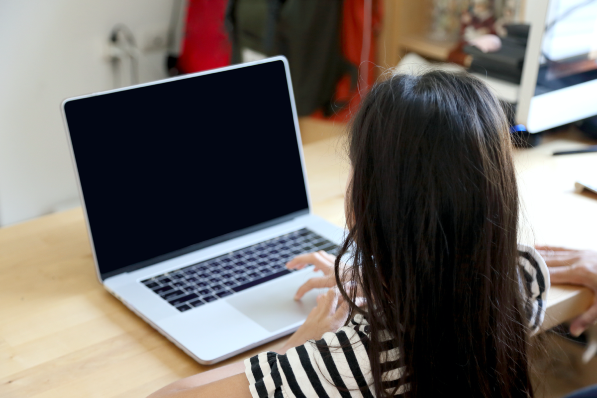 Young girl in front of a dark computer screen.