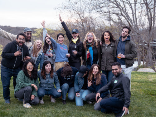 A group of employees posing for a photo outside.