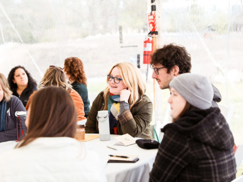 Employees sitting around a table and chatting.