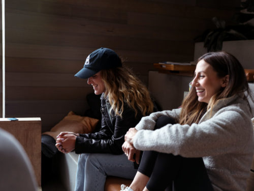 Two employees sitting next to each other and laughing.