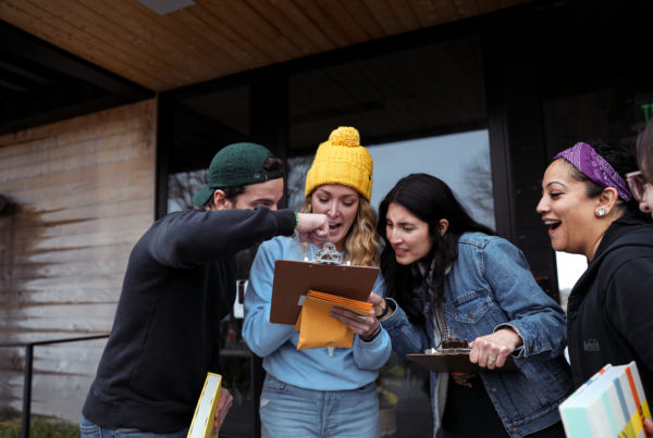 Several employees looking at a clipboard and problem solving during an event.