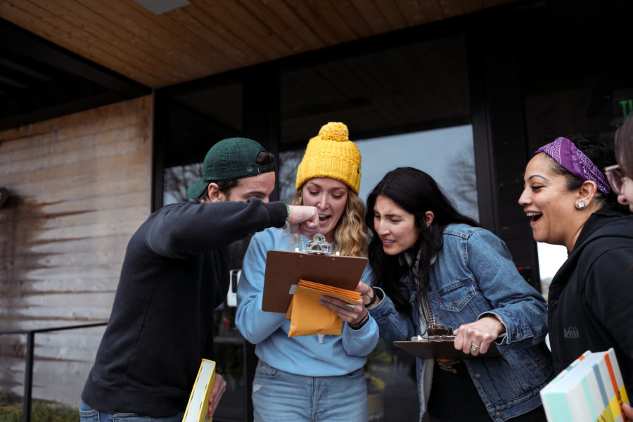Several employees looking at a clipboard and problem solving during an event.