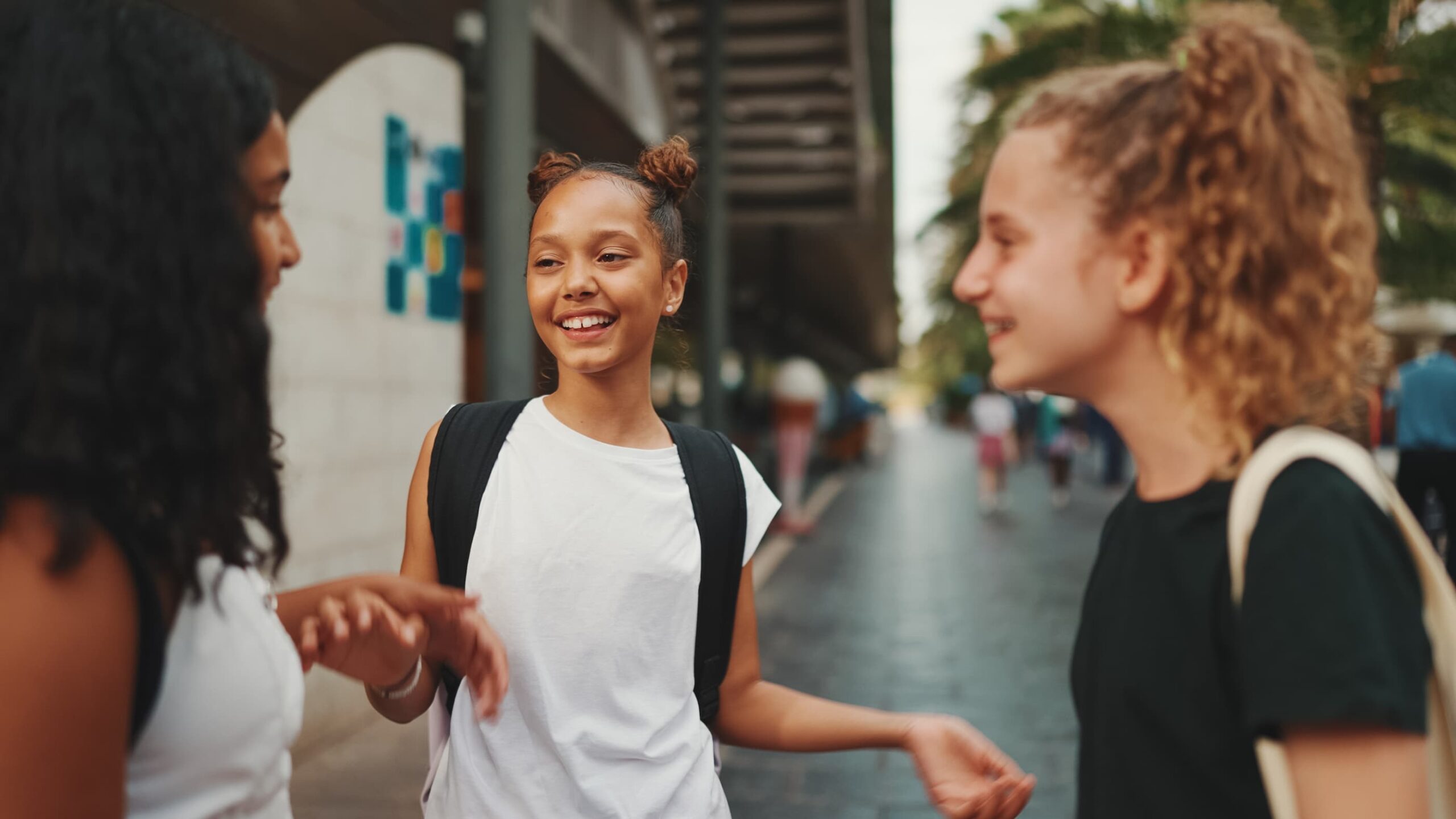 Three young girls enjoy a casual conversation.