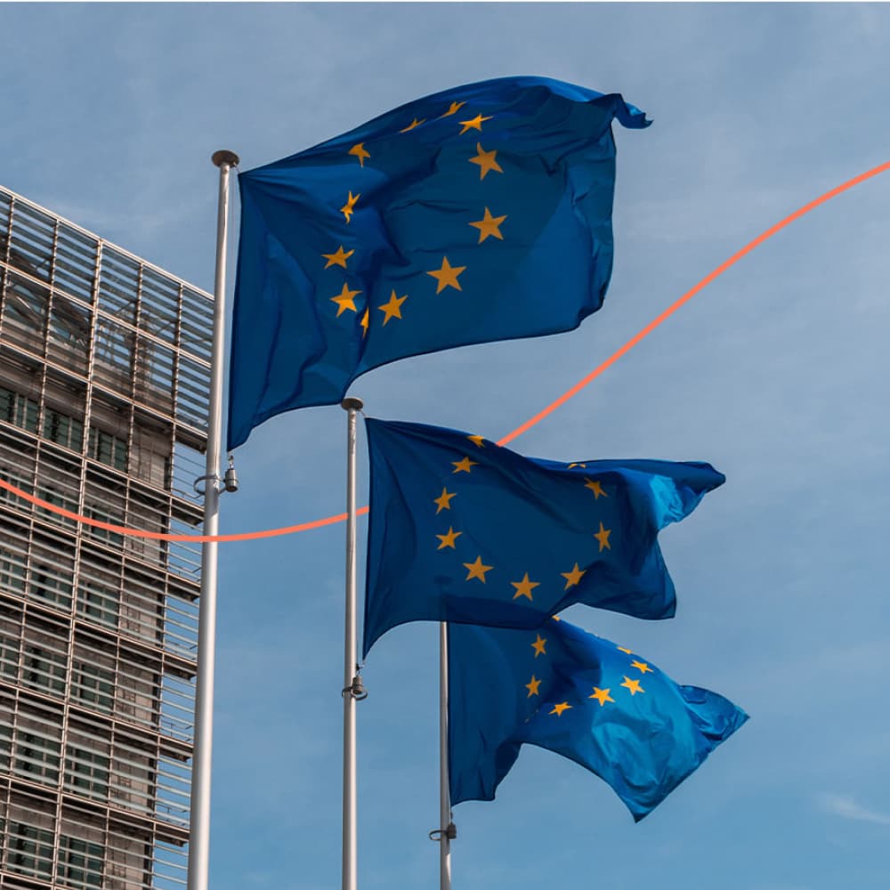 Three EU flags wave in the wind.