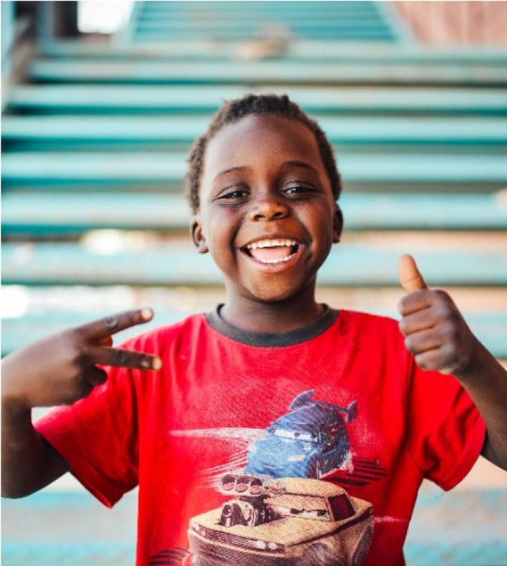 happy young boy in red shirt giving a thumbs up
